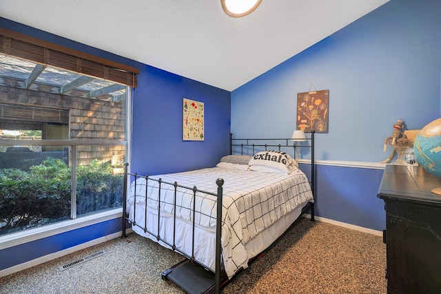 bedroom with visible vents, baseboards, carpet, and vaulted ceiling