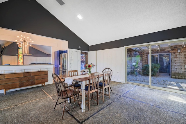 dining area featuring high vaulted ceiling, an inviting chandelier, and a textured ceiling