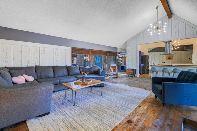 living area with high vaulted ceiling, hardwood / wood-style flooring, a textured ceiling, beamed ceiling, and a chandelier