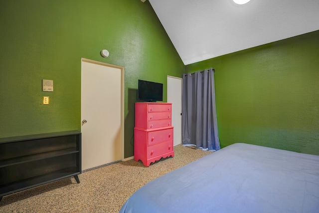 carpeted bedroom featuring vaulted ceiling and a textured wall