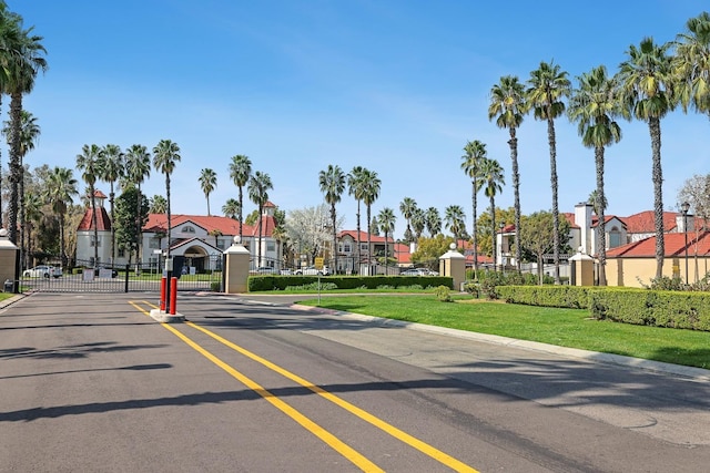 8153 N Cedar Ave Unit 106, Fresno, CA 93720 - view of asphalt road featuring a gate, curbs, a residential view, and a gated entry