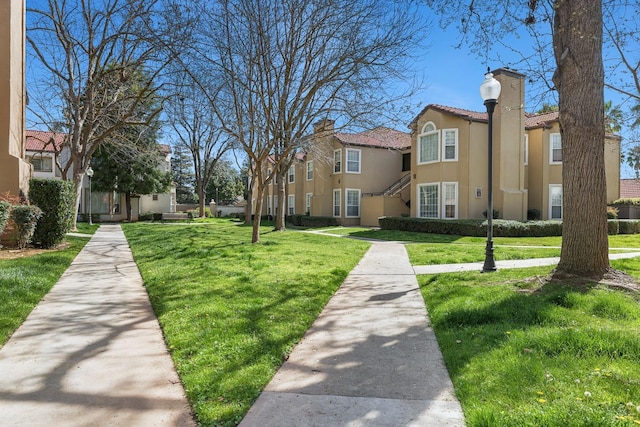 view of property's community featuring a residential view and a yard