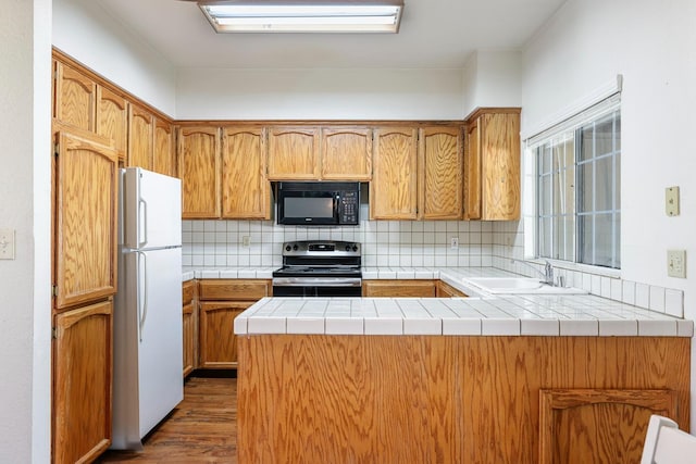 8153 N Cedar Ave Unit 106, Fresno, CA 93720 - kitchen featuring black microwave, freestanding refrigerator, stainless steel electric range, a sink, and a peninsula
