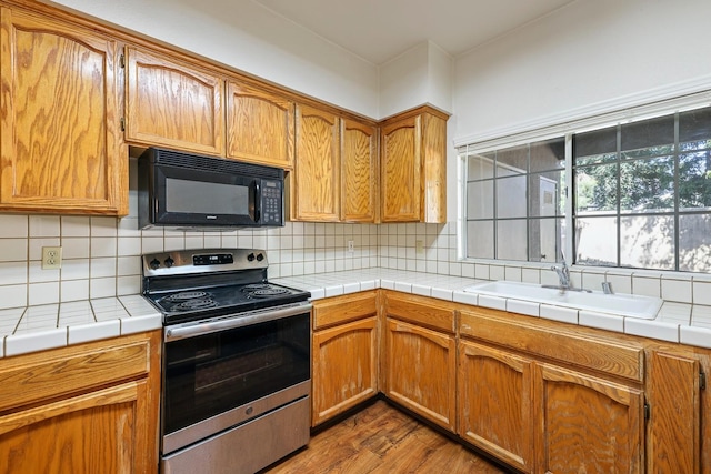 8153 N Cedar Ave Unit 106, Fresno, CA 93720 - kitchen with black microwave, electric range, a sink, dark wood-style floors, and tasteful backsplash