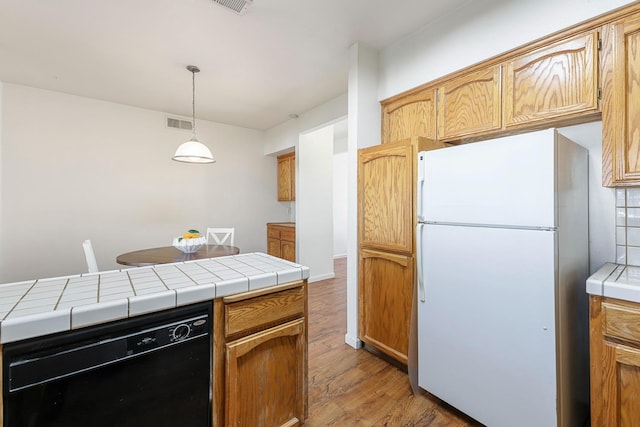 8153 N Cedar Ave Unit 106, Fresno, CA 93720 - kitchen with freestanding refrigerator, dishwasher, light wood finished floors, tile counters, and pendant lighting
