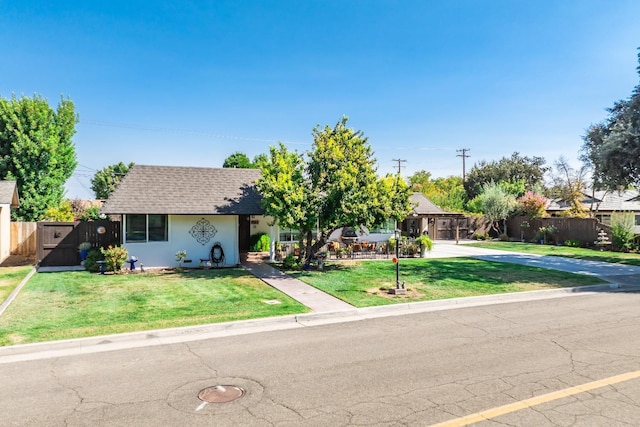 single story home featuring stucco siding, a front lawn, a gate, fence, and a shingled roof