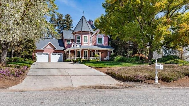 26189 Valerie Ave, Madera, CA 93638 - victorian house with a porch, concrete driveway, a garage, and a front yard