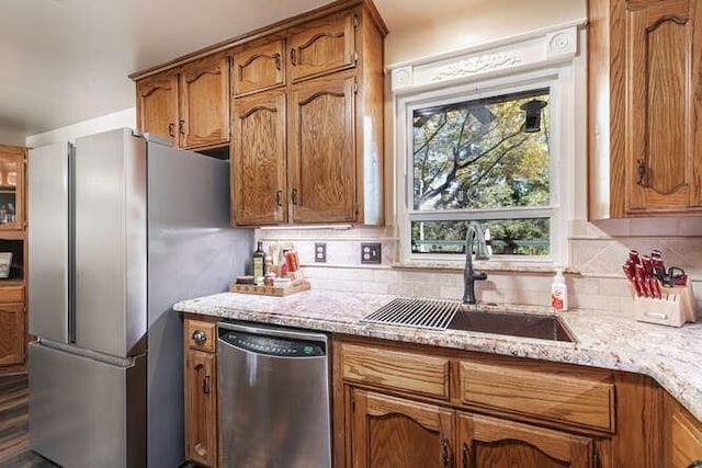 26189 Valerie Ave, Madera, CA 93638 - kitchen featuring stainless steel appliances, a sink, brown cabinetry, and tasteful backsplash