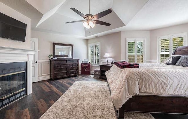 26189 Valerie Ave, Madera, CA 93638 - bedroom with wood finished floors, a glass covered fireplace, wainscoting, a raised ceiling, and a decorative wall