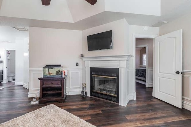 26189 Valerie Ave, Madera, CA 93638 - living area featuring a ceiling fan, wood finished floors, a glass covered fireplace, wainscoting, and a decorative wall