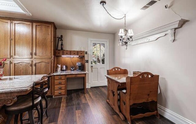 26189 Valerie Ave, Madera, CA 93638 - dining room featuring a chandelier, dark wood-style flooring, and baseboards