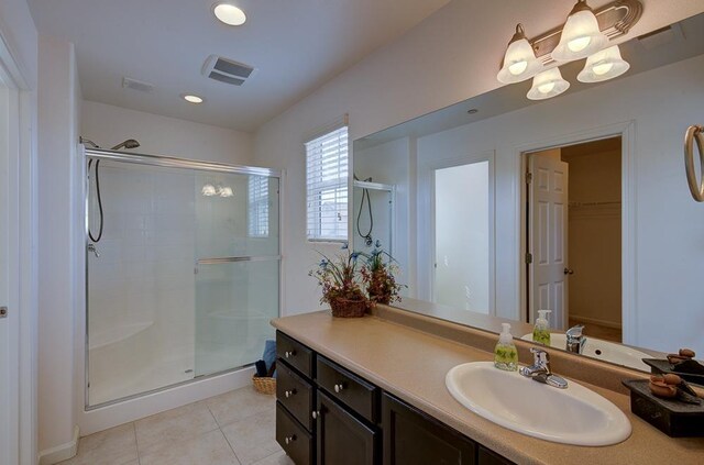 full bathroom featuring visible vents, a stall shower, vanity, and tile patterned flooring