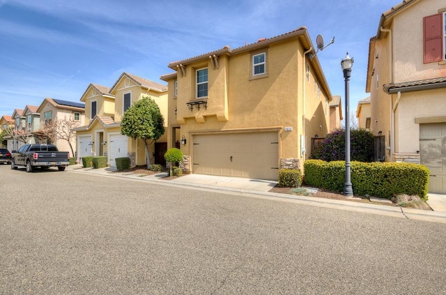 view of front of property featuring a residential view, stucco siding, and an attached garage