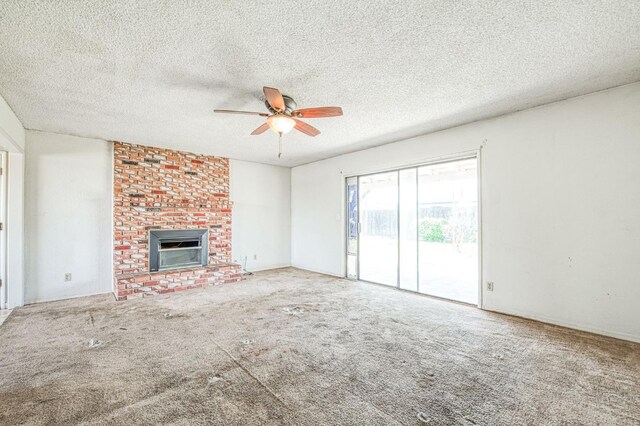 unfurnished living room featuring carpet flooring, a brick fireplace, a textured ceiling, and ceiling fan