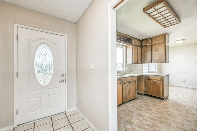 foyer entrance with a textured ceiling and baseboards