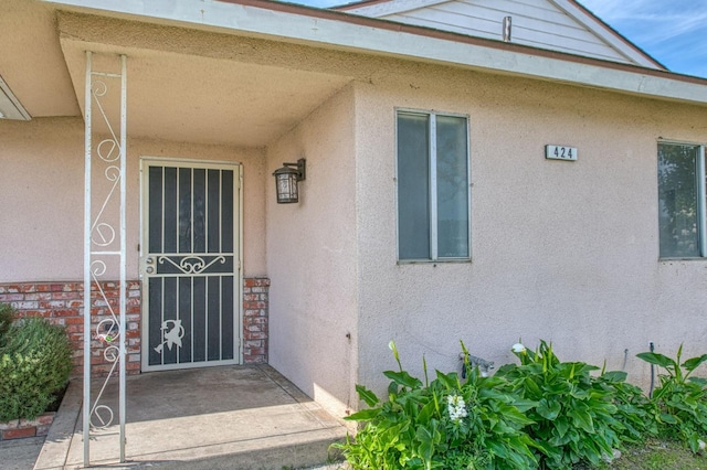 entrance to property featuring stucco siding