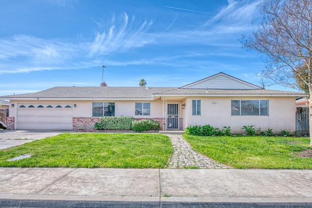 single story home with driveway, stucco siding, a front lawn, a garage, and brick siding