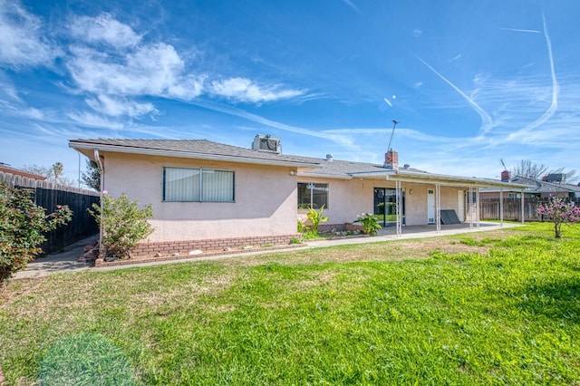 back of house featuring a yard, stucco siding, a patio, and fence