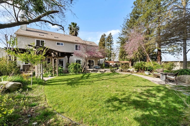 back of house with a chimney, stucco siding, a lawn, and a patio