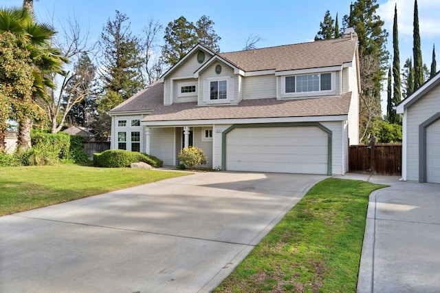 traditional-style house with a front lawn, a garage, and fence