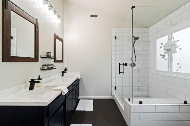 bathroom featuring visible vents, lofted ceiling, double vanity, a stall shower, and a sink