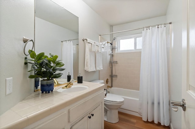 bathroom with shower / tub combo with curtain, wood finished floors, vanity, and toilet