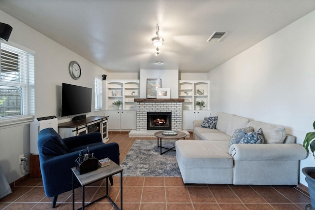 tiled living room featuring wine cooler, built in shelves, a fireplace, and visible vents