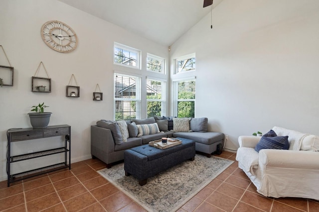 living area featuring baseboards, high vaulted ceiling, and dark tile patterned floors