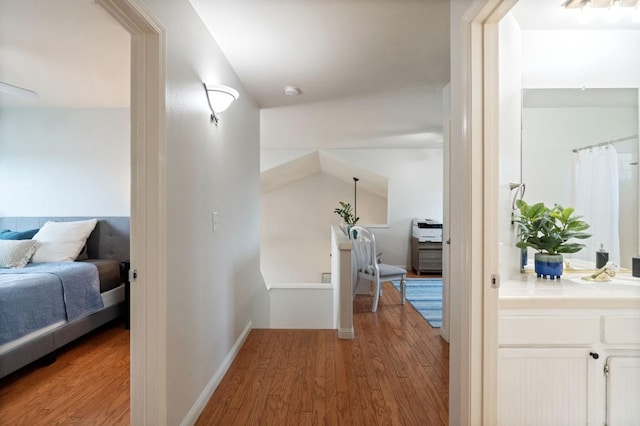 hallway featuring baseboards and light wood finished floors