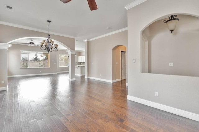 unfurnished living room featuring visible vents, ceiling fan with notable chandelier, wood finished floors, baseboards, and ornate columns