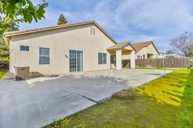 rear view of property with a yard, a patio area, fence, and stucco siding