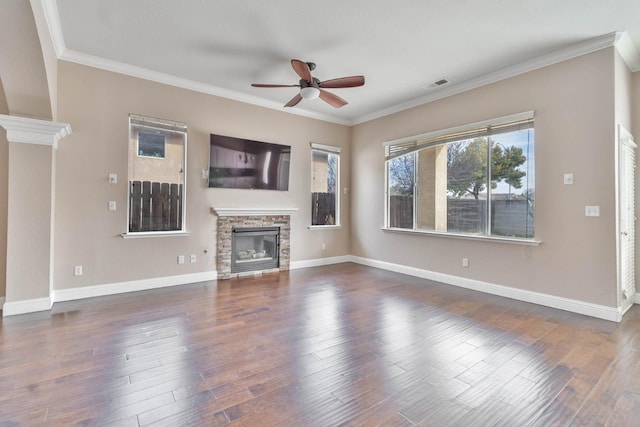 unfurnished living room featuring wood finished floors, baseboards, visible vents, a fireplace, and ornamental molding