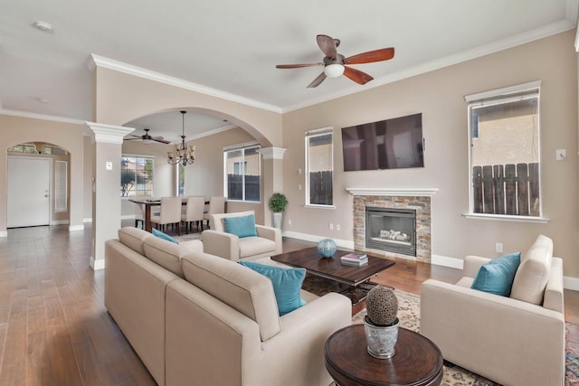 living area with arched walkways, plenty of natural light, and wood finished floors