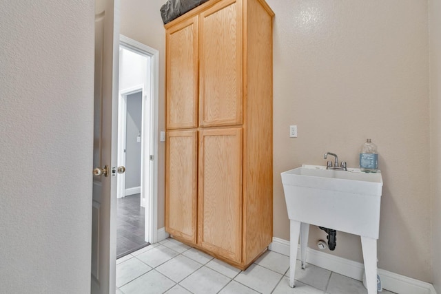 washroom with light tile patterned floors and baseboards