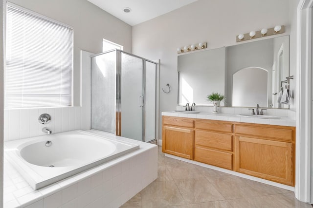 full bath featuring double vanity, a wealth of natural light, and a sink