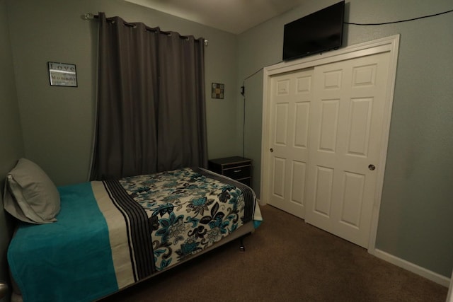 carpeted bedroom with a closet and baseboards