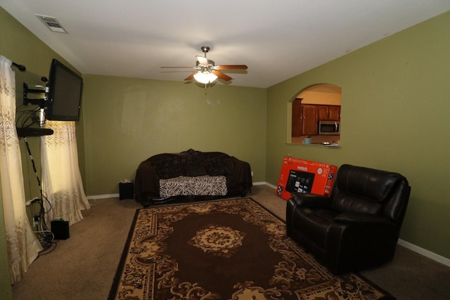 interior space featuring visible vents, carpet flooring, a ceiling fan, and baseboards