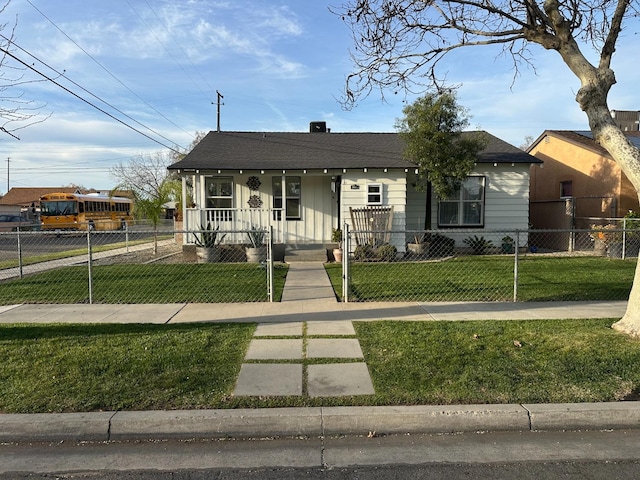 bungalow with a fenced front yard, a porch, a front lawn, and roof with shingles