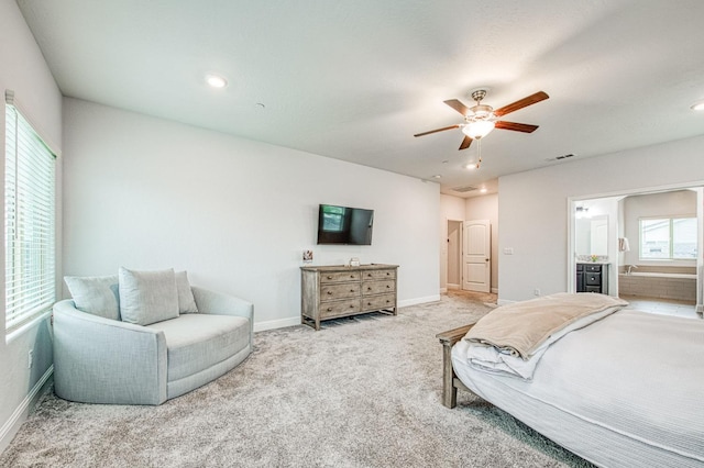 carpeted bedroom featuring visible vents, a ceiling fan, ensuite bathroom, and baseboards