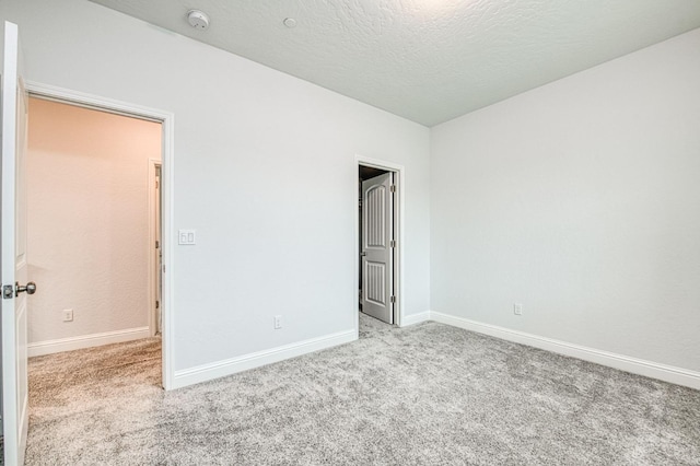 unfurnished bedroom with baseboards, carpet floors, and a textured ceiling