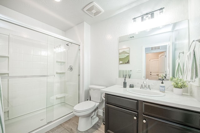 full bathroom featuring toilet, wood finished floors, visible vents, and a stall shower