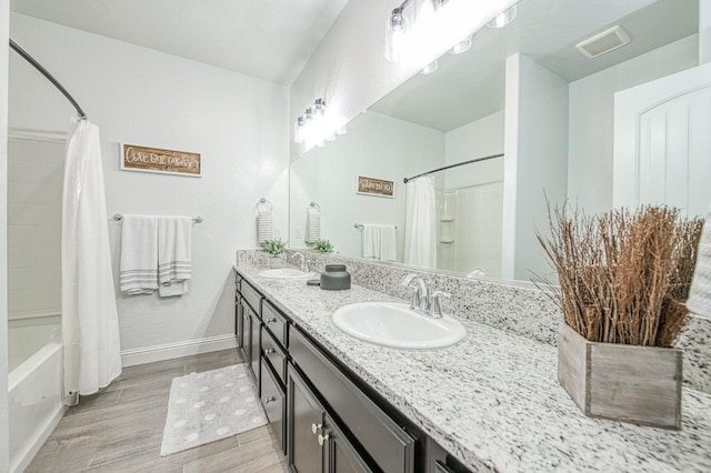 full bathroom with visible vents, wood finished floors, baseboards, and a sink