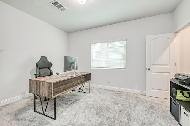 carpeted office space featuring baseboards, visible vents, and a textured ceiling