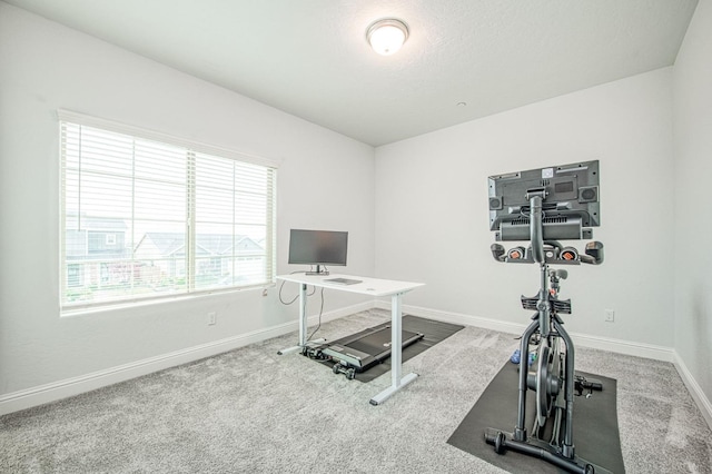 workout area featuring carpet and baseboards