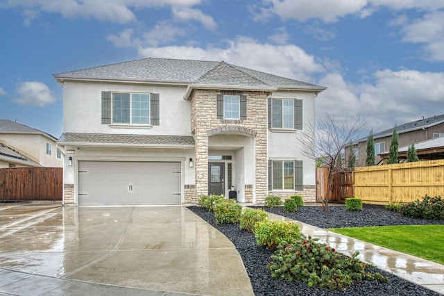 view of front of home with stucco siding, stone siding, driveway, and fence