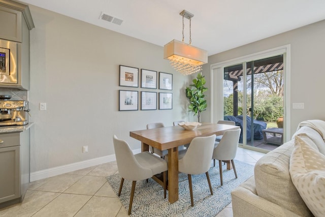 dining space featuring light tile patterned floors, visible vents, and baseboards