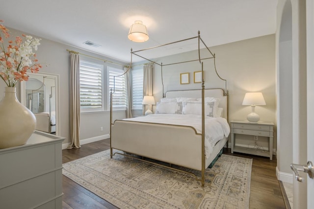 bedroom with visible vents, baseboards, and wood finished floors