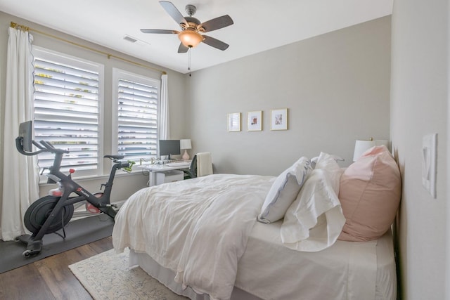 bedroom with visible vents, a ceiling fan, and wood finished floors