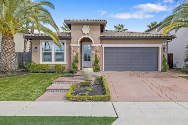 mediterranean / spanish house with stucco siding, a garage, driveway, and a tiled roof