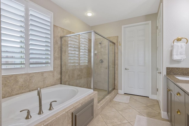 bathroom featuring a bath, tile patterned floors, a stall shower, and vanity